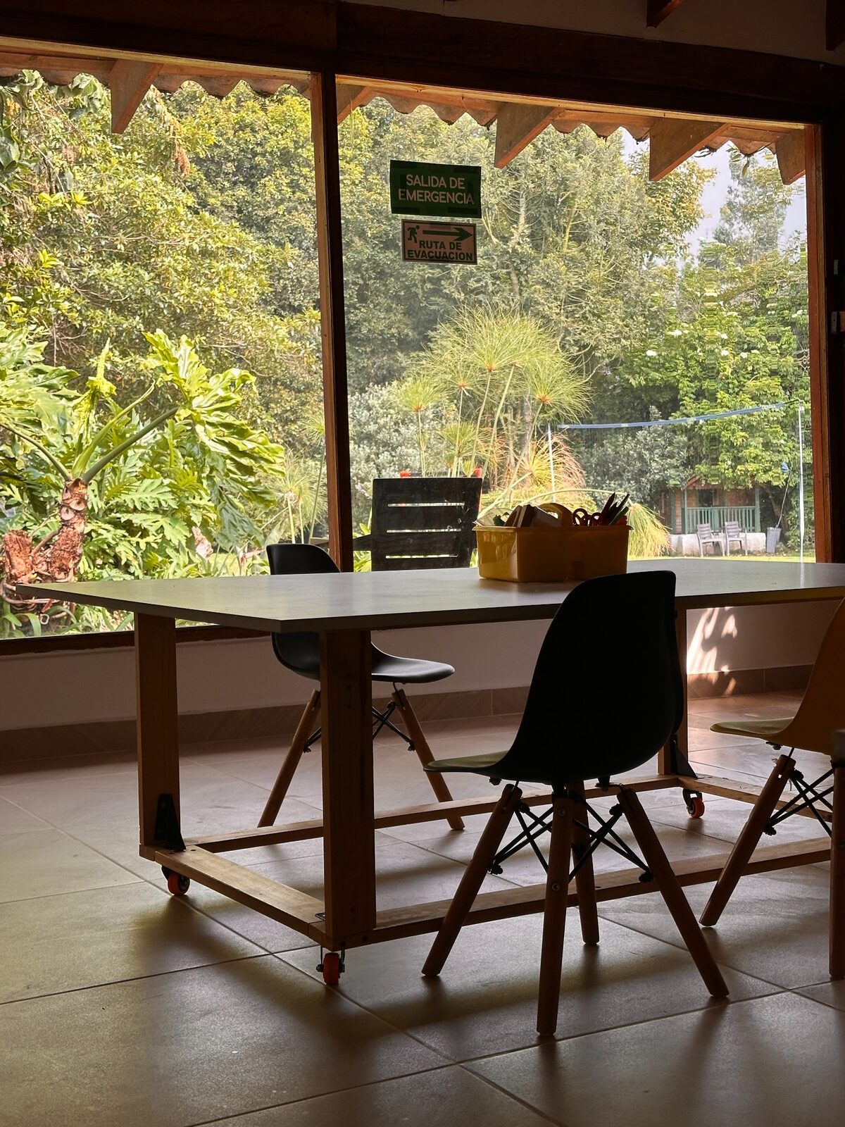 Mesa de trabajo y sillas frente a un gran ventanal con vista a la naturaleza en Hom Sabana