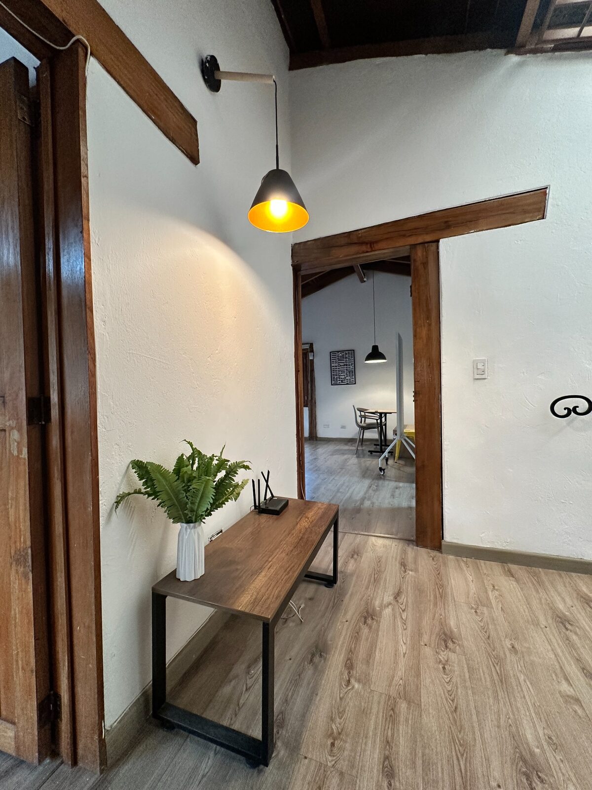 Pasillo iluminado con lámparas y acceso a espacios de estudio en Hom Sabana